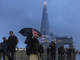 <p>Commuters make their way to work across London Bridge in the rain in London, UK, on Monday, Jan. 6, 2025. </p>