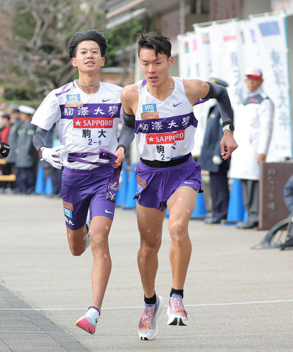 ６区、伊藤蒼唯（左）からタスキを受け取る７区の駒大・佐藤圭汰（カメラ・中島　傑）