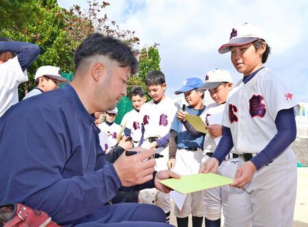 憧れのプロ野球選手からサインをゲット。少しでも近づけるように頑張ります！＝１２月２７日、那覇市立松島小学校（古謝克公撮影）