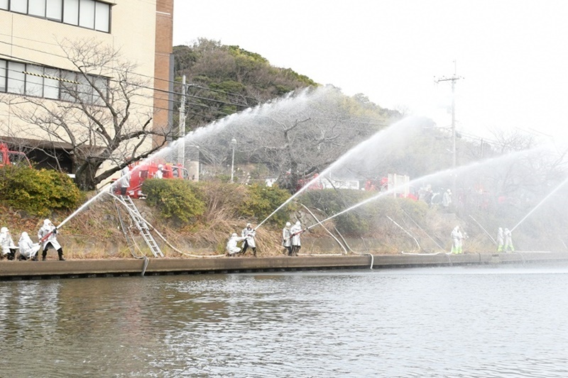 一斉放水する消防団員＝浜田市殿町、市役所裏浜田川