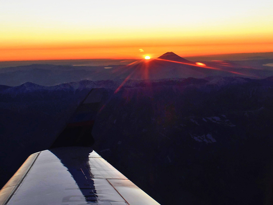 遊覧フライトの機内から見る初日の出と富士山