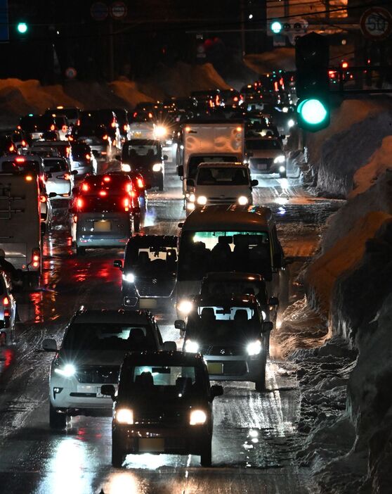 路面から雪は消えたものの路肩の雪で道幅が狭まり、帰宅などの車で混みあう幹線道路＝6日午後5時5分、青森市青葉1丁目（写真は一部加工しています）