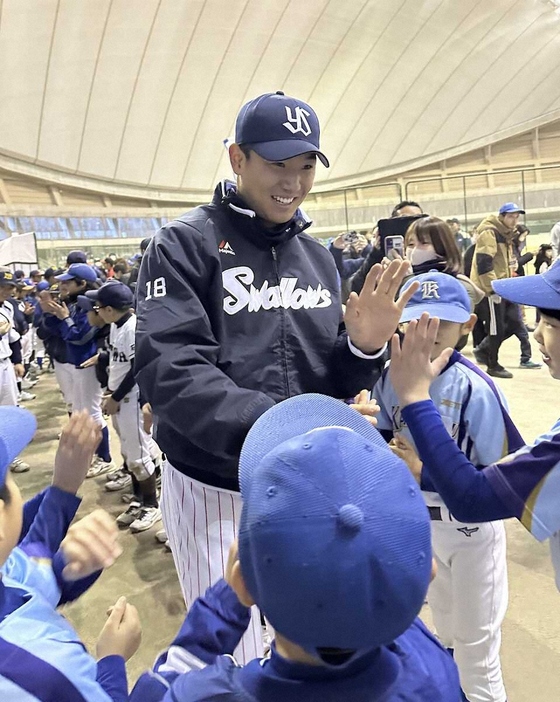 地元の小学生と笑顔でハイタッチするヤクルト・奥川