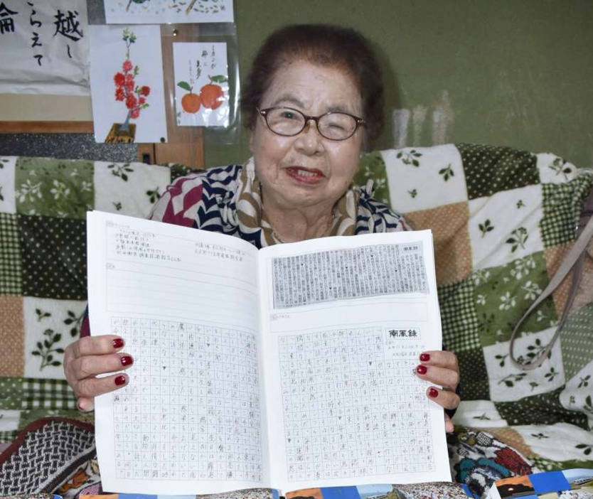 南風録を書き写したスクラップ帳を見せる緒方槇子さん＝霧島市国分府中町