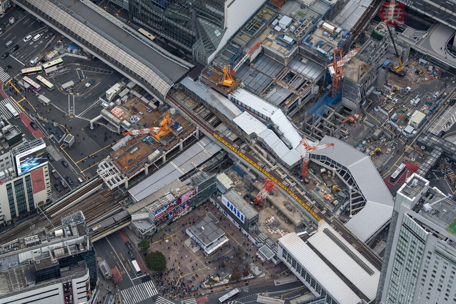 東急東横店西館と南館の解体状況。ビル解体中の真上を毎日電車が走るのは滅多にない光景である。やがて回送線路は空中回廊の建物に内包されて見えなくなる（2024年12月、吉永陽一撮影）。