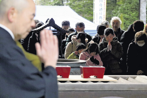 手を合わせ黙とうする人々（１日、輪島市の総持寺祖院で）