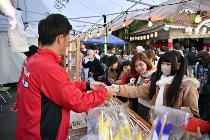 熊手や絵馬を購入する初詣客ら＝１日、糸満市の白銀堂