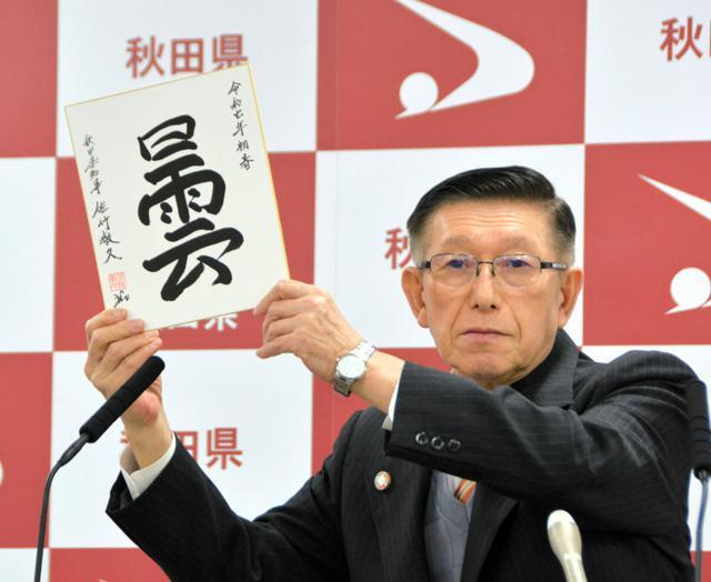 年初の一字「曇」を掲げる佐竹知事。「政治も経済も先を見通しにくい雲の下。雲を突き抜ける発想の転換、ブレークスルーが必要だ」と、選んだ理由を説明した=2025年1月6日午後1時3分、秋田市、阿部浩明撮影