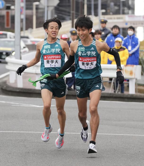 戸塚中継所でタスキリレーする青学大8区塩出（左）と9区田中（撮影・垰建太）