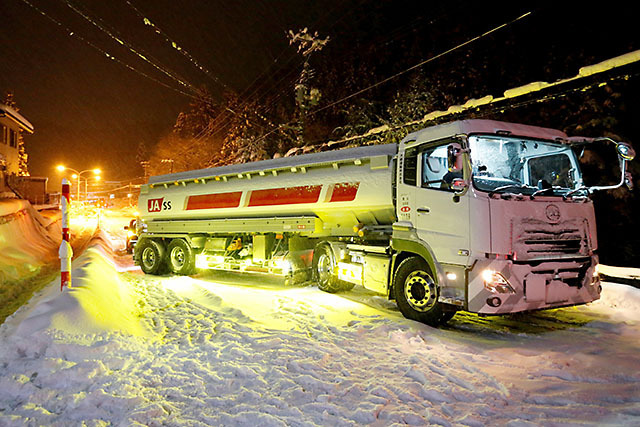 大雪の影響で坂を上れなくなった大型トレーラー＝９日午後６時10分、山形市新山・国道２８６号