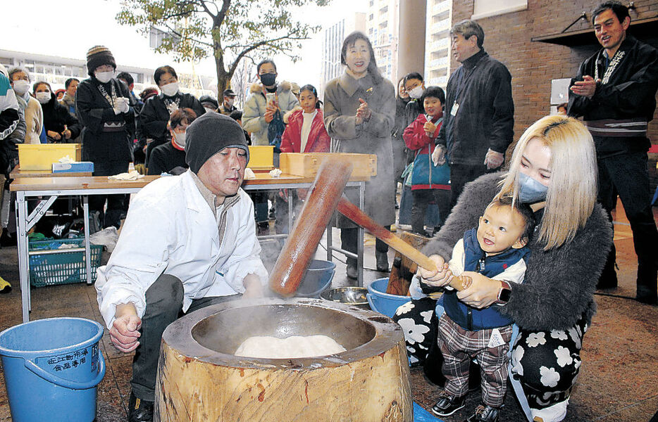 餅つきを楽しむ来場者＝金沢市の近江町いちば館広場