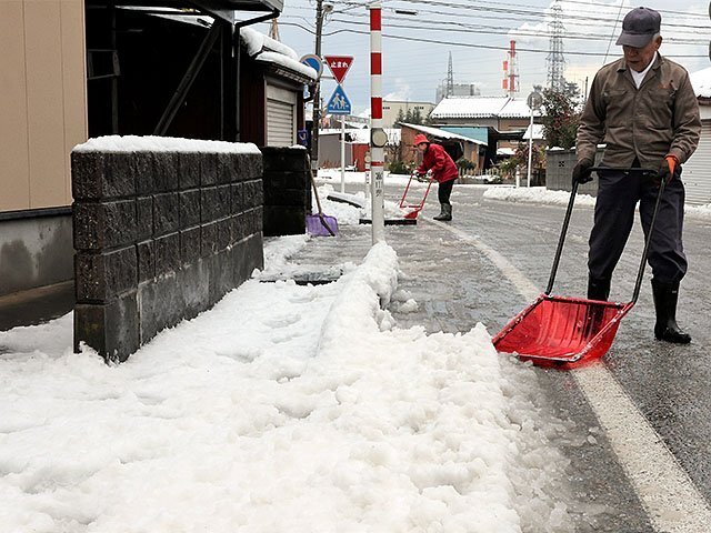 自宅前を除雪する住民＝９日午前９時２５分ごろ、高岡市能町