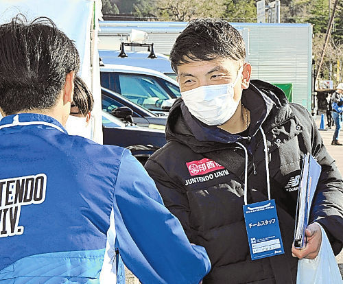 走り終えた選手をねぎらう順大の今井コーチ