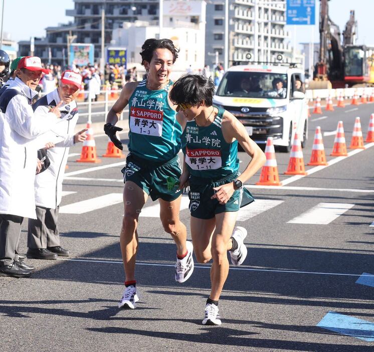 報知代表07【第101回箱根駅伝　往路】平塚中継所でタスキをつなぐ青学大3区の鶴川正也（左）と青学大4区の太田蒼生（代表撮影）＝報知写真部2025年1月2日撮影＝平塚中継所（代表撮影）