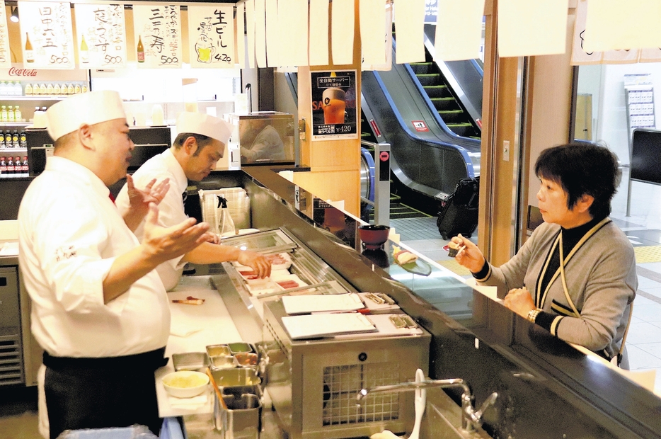 店内で接客する小林専務（左）