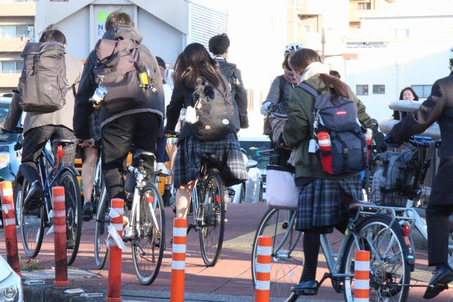 通勤・通学時間帯の徳島市のかちどき橋。ヘルメットを着用していない高校生の姿が目立つ=昨年12月9日午前8時15分ごろ、同市万代町1