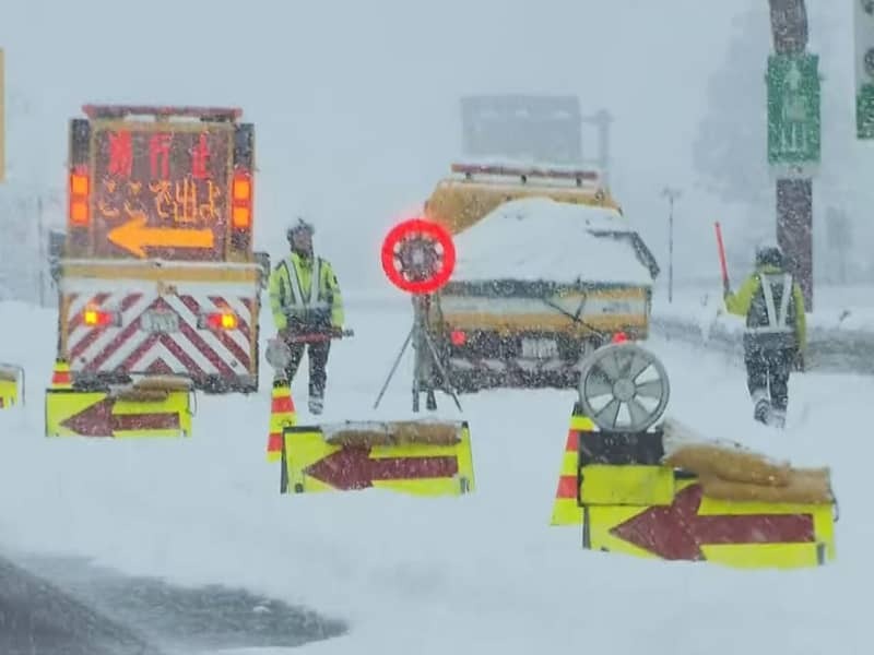 大雪で通行止めになり、車を誘導する関係者＝８日午後、郡上市白鳥町、東海北陸自動車道