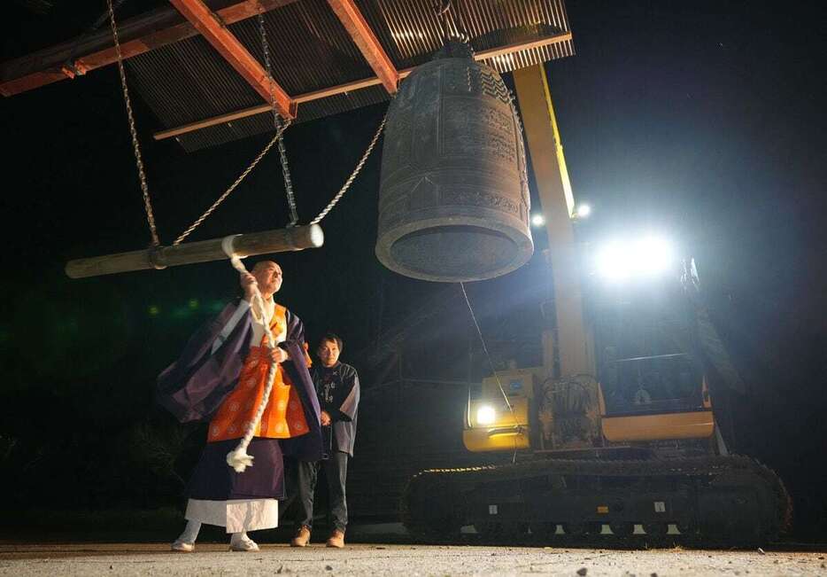 1日未明、重機に吊らされた「除夜の鐘」。被災地に響き渡った　＝石川県珠洲市（鴨川一也撮影）