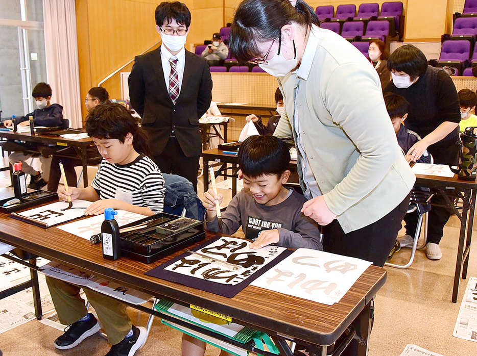 心を込めて書に向かう児童ら＝6日、鹿児島県宇検村の元気の出る館