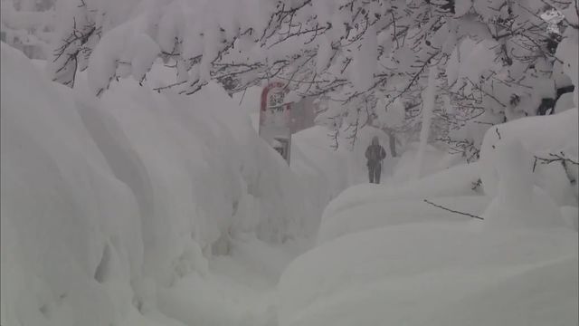 弘前城周辺の歩道。雪が大人の背丈以上となりバス停も埋まっている。（4日午前　青森県弘前市）