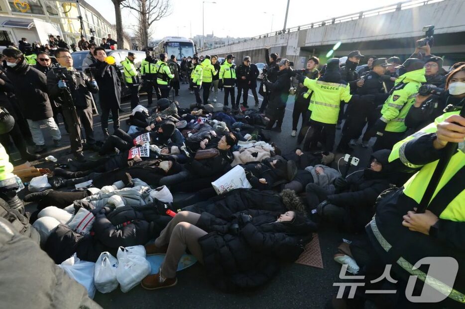 2日、ソウル市龍山区の大統領官邸前で、警察による解散命令に対抗して横たわる保守団体メンバーや支持者ら(c)news1