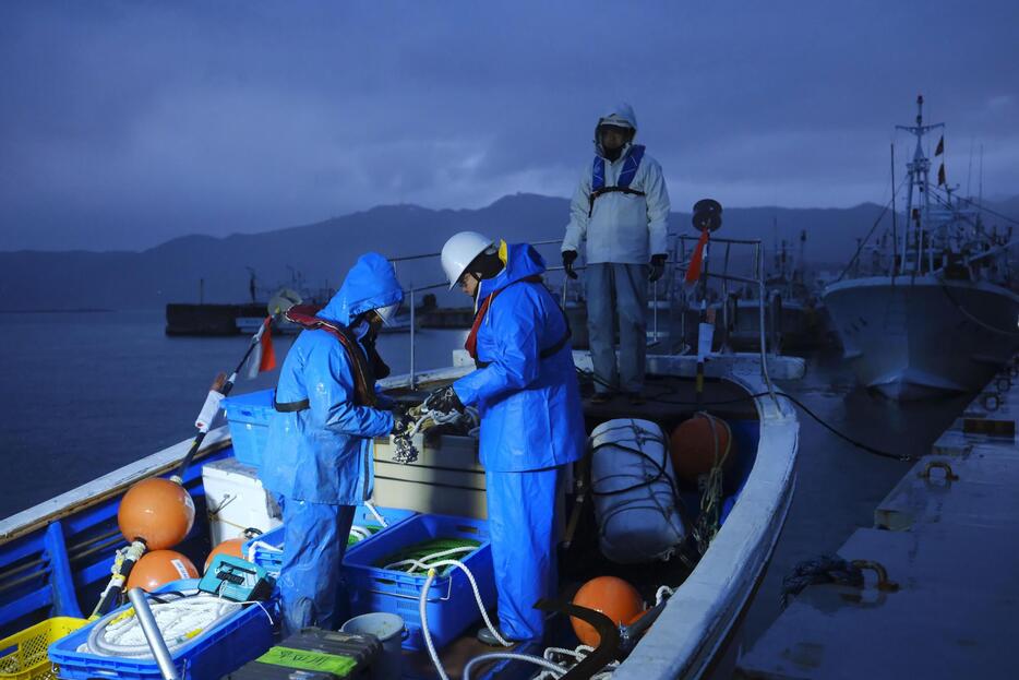 調査海域に向かうため、出港準備する環境調査会社の社員ら＝2024年12月10日早朝、石川県輪島市の輪島港