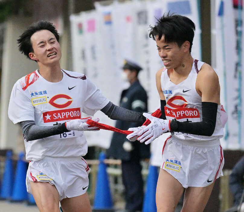 復路の小田原中継所でたすきをつなぐ中大の６区・浦田優斗（左）と７区の岡田開成＝３日、神奈川県小田原市