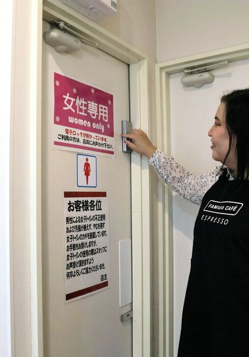 女性トイレに取り付けられたオートロックの電子錠。利用者はドアの前で解錠を待つ