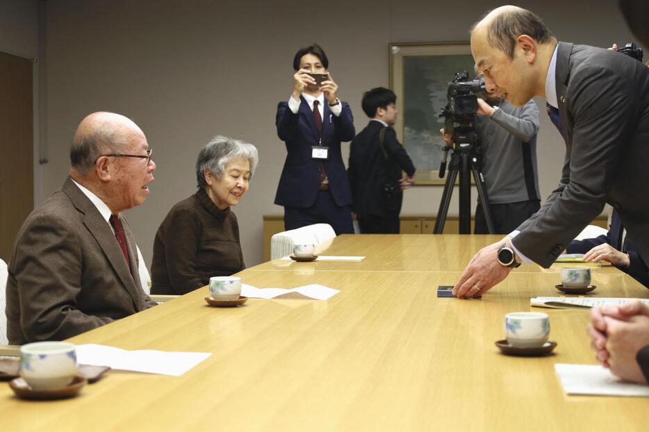 長崎市の鈴木史朗市長（右）を表敬訪問し、ノーベル平和賞授賞式で受け取ったメダルのレプリカを見せる長崎被災協の田中重光会長（左手前）ら＝9日午前、長崎市役所