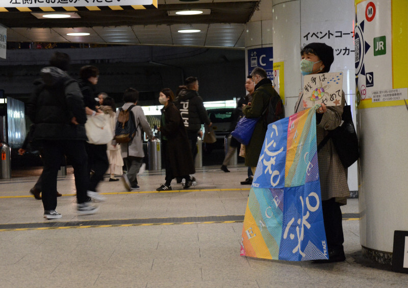 プラカードを掲げて平和を訴える大木晴子さん＝新宿駅西口地下広場で2024年12月21日午後6時2分、斎藤良太撮影