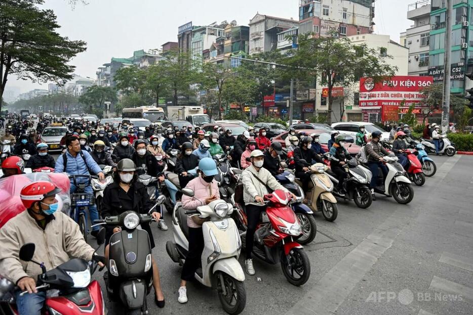 ベトナム・ハノイの交差点で、赤信号のため止まっているバイクと車両（2025年1月8日撮影）。【翻訳編集】 AFPBB News