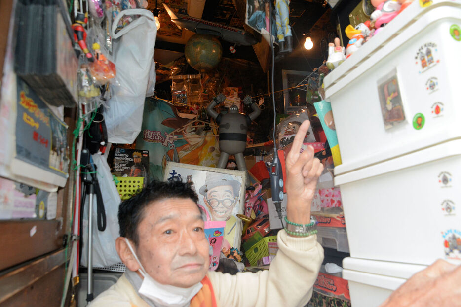 店内と鈴木さん。店内は所狭しとグッズが置かれている