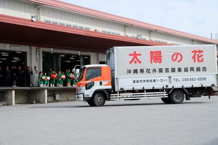 組合員や関係者の見送りを受け、集荷や出荷に向かう初荷車両＝３日、沖縄県浦添市・県花卉園芸農業協同組合