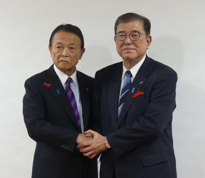 麻生太郎氏と握手する石破茂首相（2024年10月9日撮影）