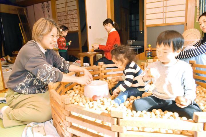 木の球プールで思い思いに遊ぶ子どもを見守る高橋佐智子さん（左）＝松山市平田町