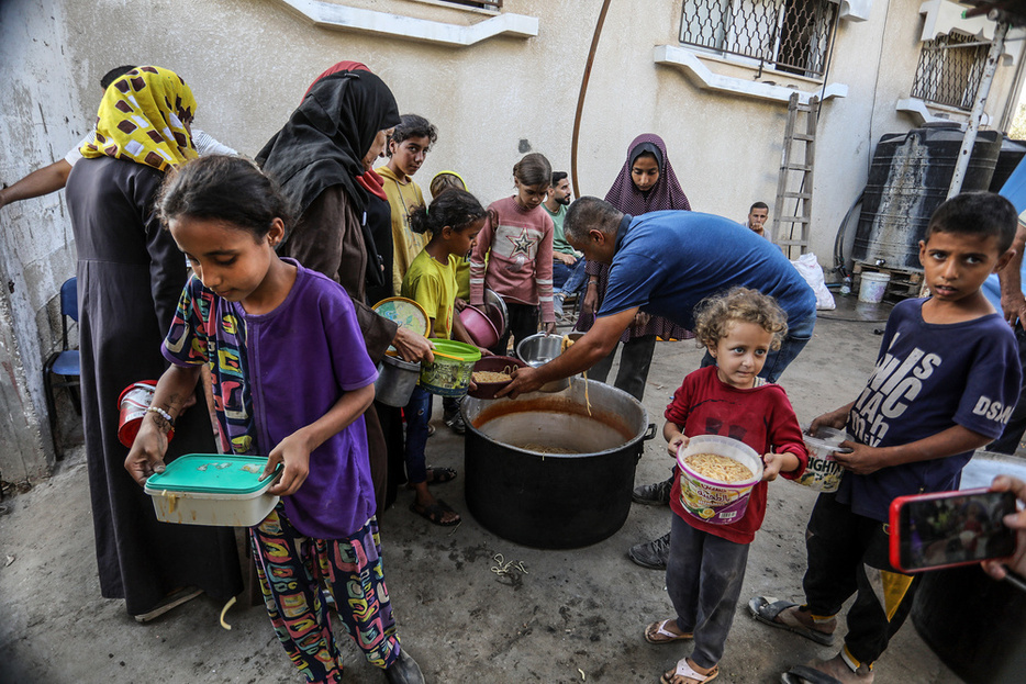 ガザ中部デールバラハで食べ物を配る世界食糧計画（WFP）＝昨年10月（ゲッティ＝共同）