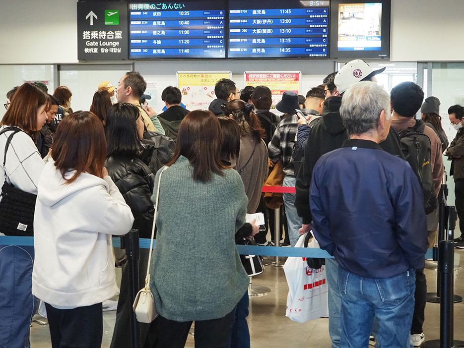 奄美空港の2階の手荷物検査場やロビーは多くの人で混みあった (4日午前10時半頃)