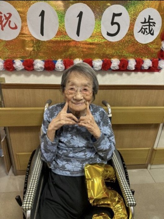 115歳の誕生日を祝福されポーズをとる林おかぎさん＝家族提供