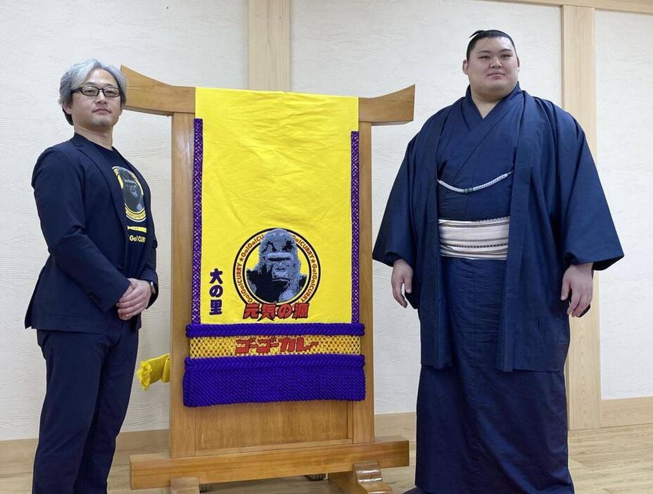 ゴーゴーカレーの西畑誠社長（左）から化粧まわしを贈られた大の里＝8日、茨城県阿見町の二所ノ関部屋