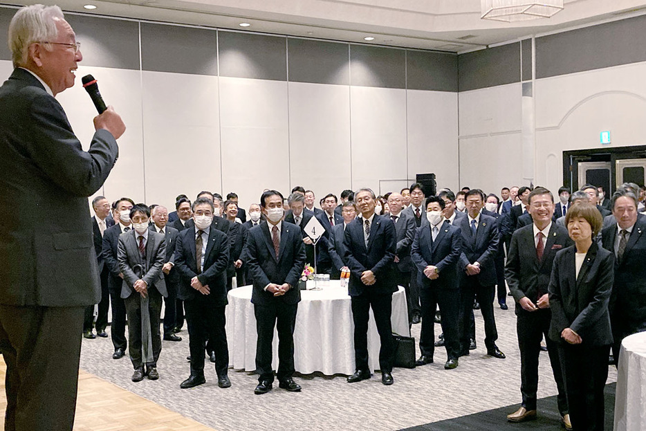 田中会頭（左）による年頭のあいさつを聞く会員と来賓ら＝高町の華王殿で