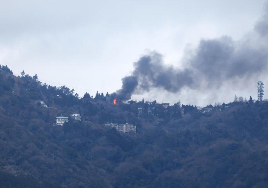 炎と黒煙が見える六甲山上＝１０日午後１時１９分、神戸市中央区東川崎町から