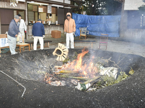 【正月飾りをたき上げる氏子や総代ら＝津市久居元町の川併神社で】