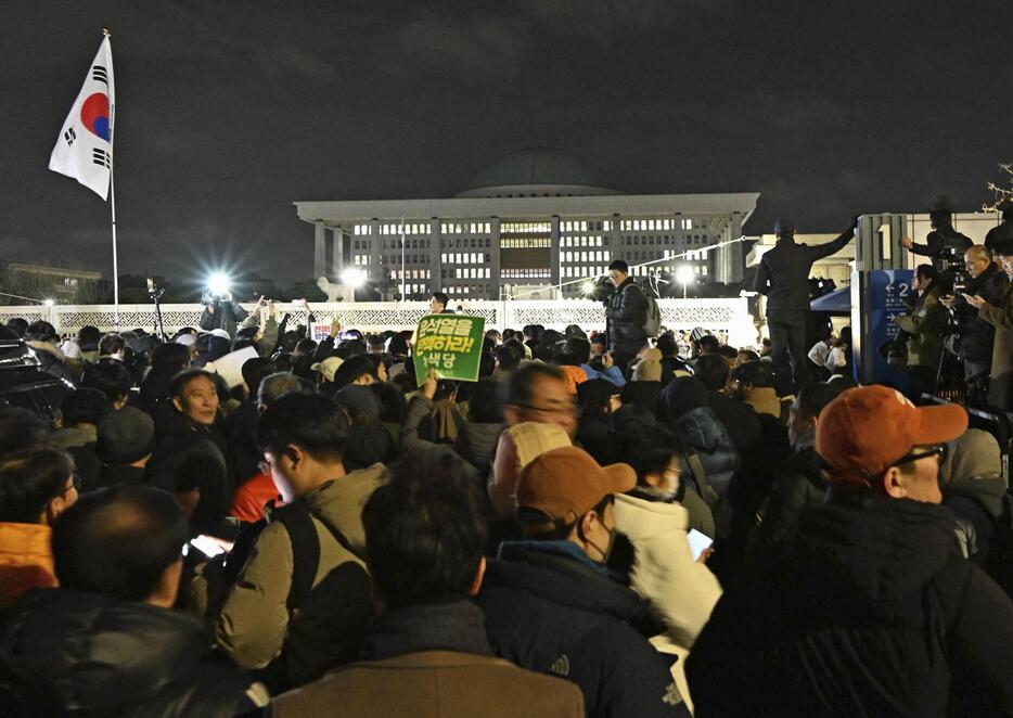 昨年12月4日、韓国の尹錫悦大統領が宣言した「非常戒厳」に反発し、ソウルの国会周辺に集まった人々（共同）