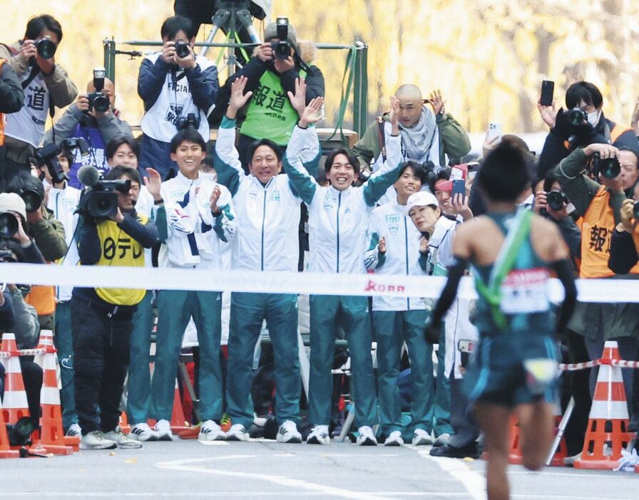 ゴールするアンカーの小河原陽琉（背中）を迎える青学大の原晋監督（中央）、出場選手ら