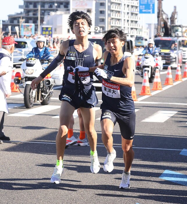 平塚中継所でタスキをつなぐ東洋大3区の迎暖人(左)と、4区の岸本遼太郎（代表撮影）