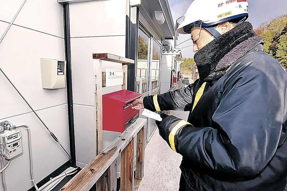 仮設住宅団地へ年賀状を届ける局員＝１日午前８時４５分、能登町松波