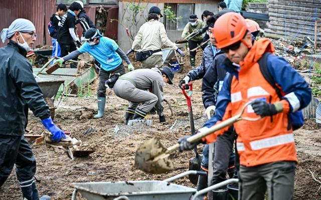 瀬野千草さんの畑に流れ込んだ土砂をかき出すボランティアたち=2024年10月20日午前10時51分、石川県輪島市町野町、金居達朗撮影