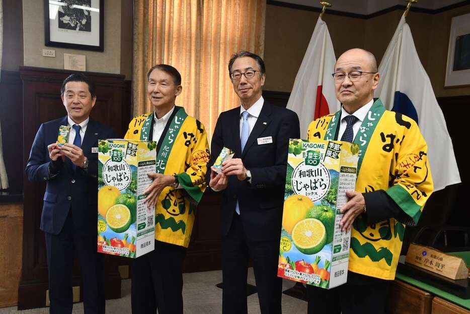 和歌山県北山村特産のじゃばらを使った野菜ジュースをPRする岸本周平知事（左2人目）、泉清久村長（右）とカゴメ関係者＝和歌山市