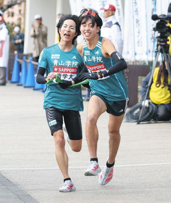 小田原中継所で野村昭夢からたすきを受け取る青学大・白石光星（右）