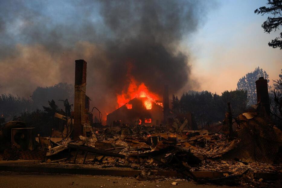 ロサンゼルス地域での山火事で火に包まれる建物（ロイター）